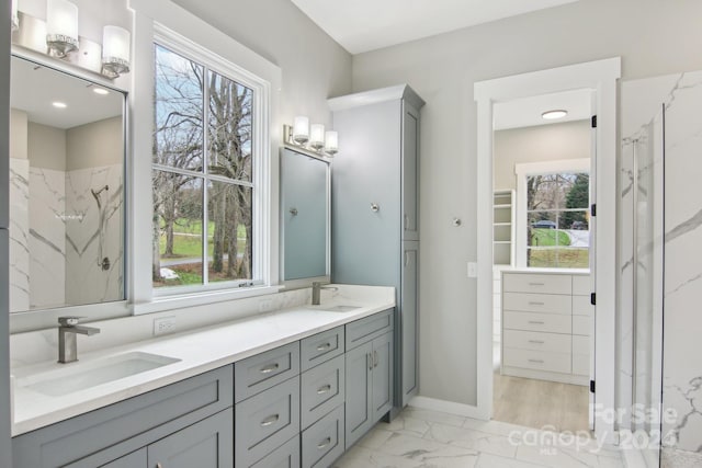 bathroom featuring a shower, vanity, and a healthy amount of sunlight