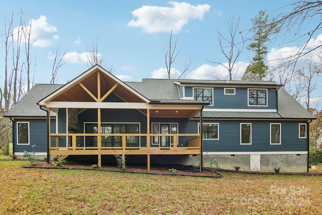 rear view of property featuring a lawn