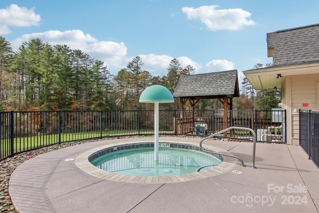 view of swimming pool with a hot tub and a patio area