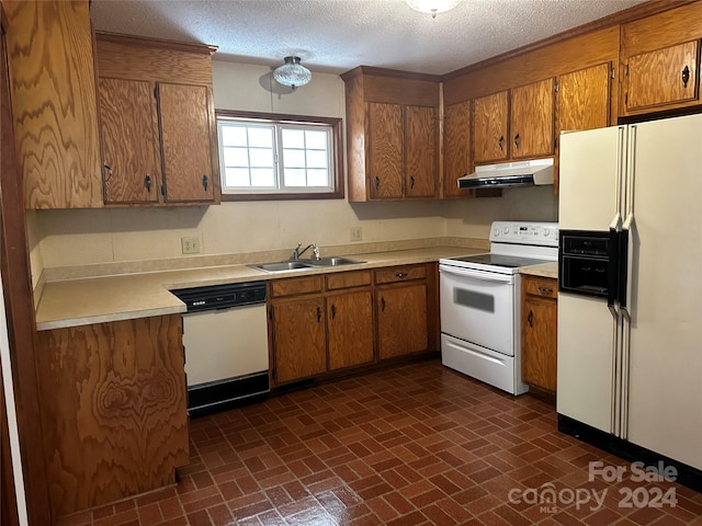 kitchen featuring white appliances, a textured ceiling, and sink