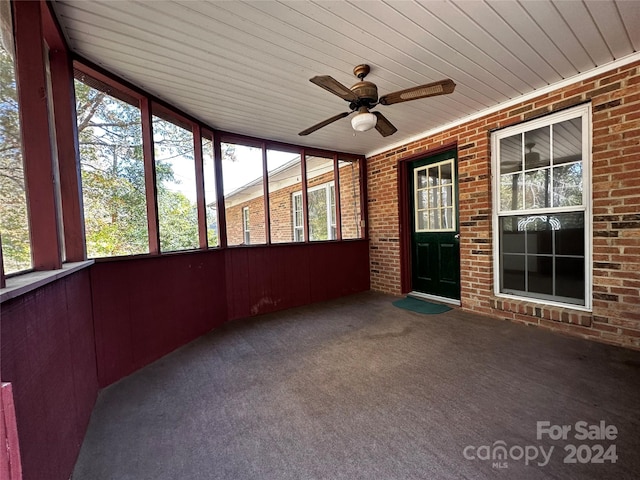 unfurnished sunroom with ceiling fan and wood ceiling