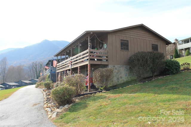 view of property exterior with a mountain view and a yard