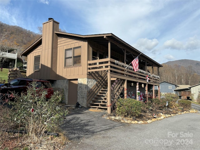12 Boulder Ln, Maggie Valley, NC 28751 - view of front of property with board and batten siding, a mountain view, a chimney, and stairs