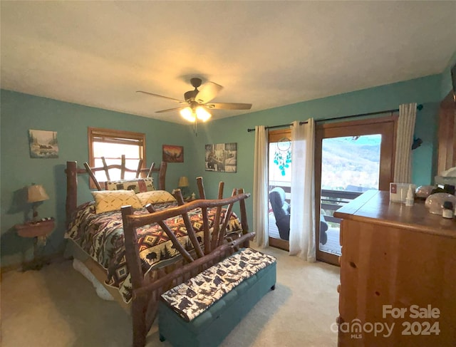 bedroom featuring ceiling fan, light colored carpet, multiple windows, and access to exterior