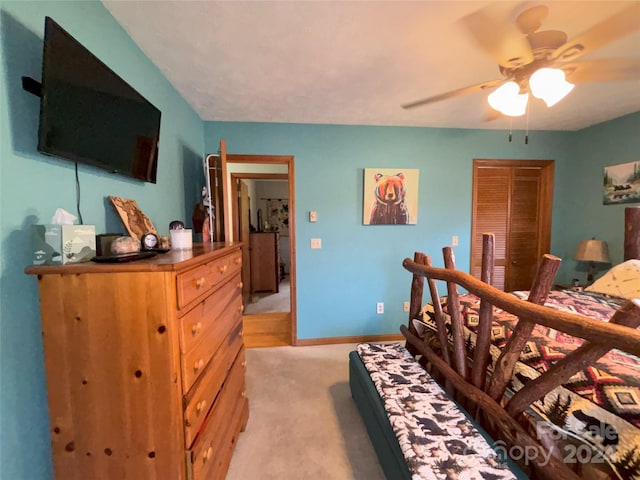 bedroom with light colored carpet, ceiling fan, and a closet