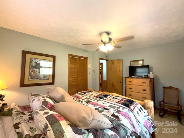 carpeted bedroom with ceiling fan and a closet