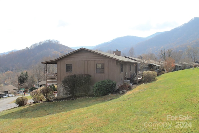 view of side of property with a lawn and a mountain view