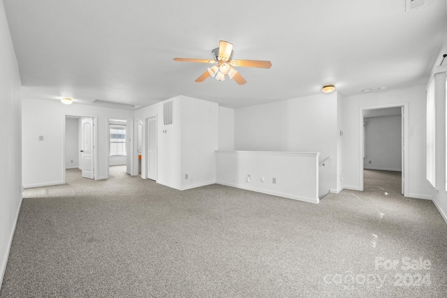 unfurnished living room featuring ceiling fan and light carpet