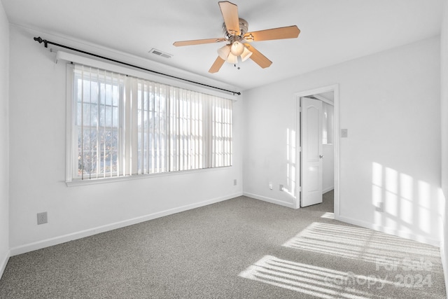 carpeted spare room featuring ceiling fan