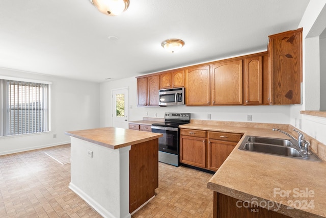 kitchen with sink, a kitchen island, and appliances with stainless steel finishes