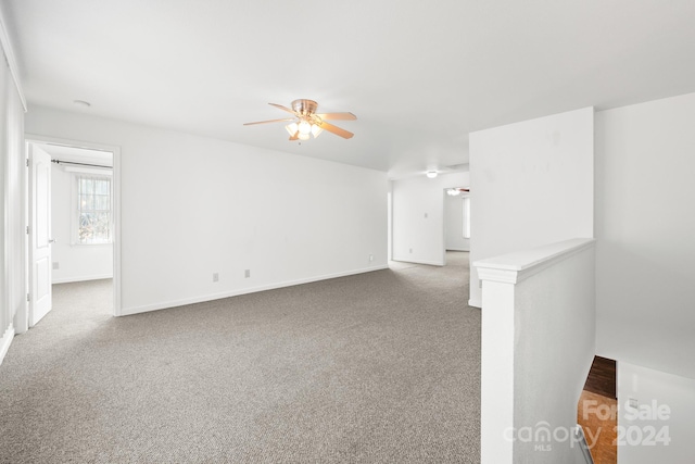 unfurnished living room featuring ceiling fan and carpet