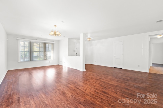 unfurnished living room with dark wood-type flooring and a chandelier