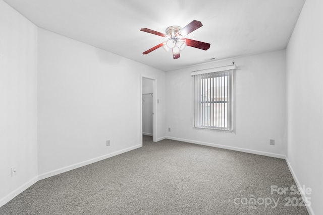 unfurnished room with ceiling fan and carpet