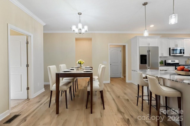 dining area featuring a notable chandelier, light hardwood / wood-style floors, and ornamental molding