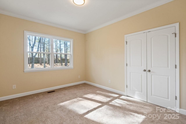 unfurnished bedroom featuring light colored carpet, a closet, and ornamental molding