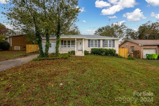 ranch-style home with a front lawn, a garage, and covered porch