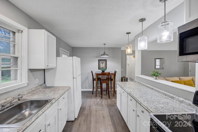 kitchen with pendant lighting, plenty of natural light, white cabinets, and sink