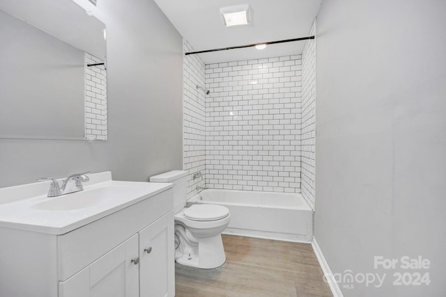 full bathroom featuring toilet, tiled shower / bath combo, vanity, and hardwood / wood-style floors