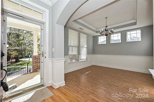 interior space featuring a healthy amount of sunlight, a raised ceiling, and wood-type flooring