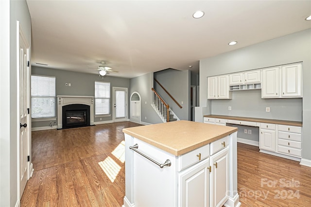 kitchen featuring white cabinets, light wood-type flooring, a center island, and ceiling fan