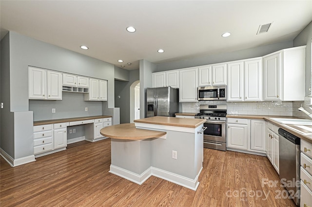 kitchen featuring a kitchen island, light wood-type flooring, white cabinetry, and appliances with stainless steel finishes