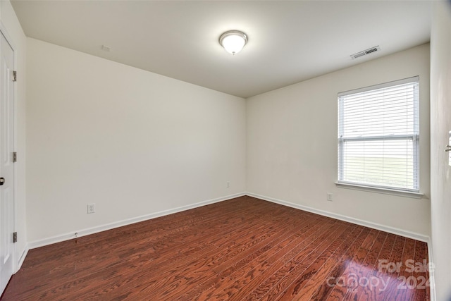 unfurnished room with dark wood-type flooring