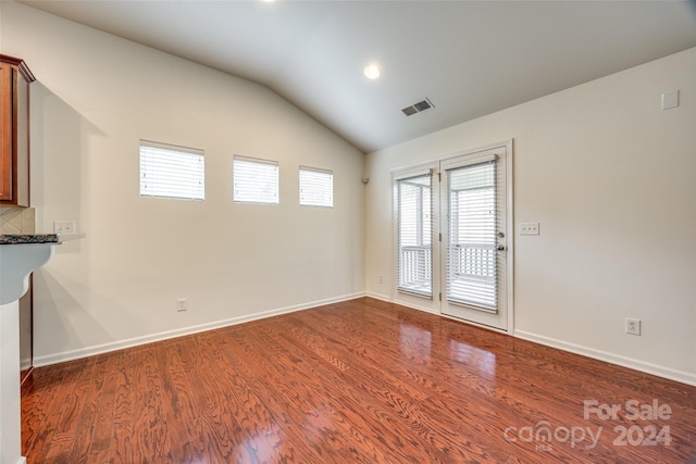 empty room with hardwood / wood-style flooring and lofted ceiling