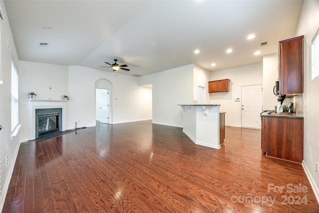 unfurnished living room with dark hardwood / wood-style flooring and ceiling fan