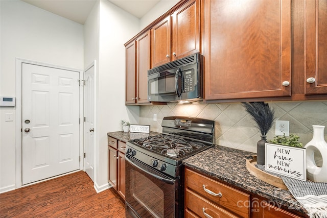 kitchen featuring black appliances, dark stone counters, decorative backsplash, and dark hardwood / wood-style floors