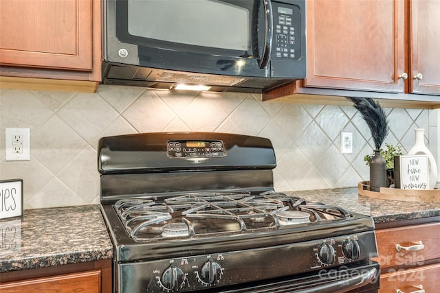 kitchen with black appliances, backsplash, and dark stone countertops