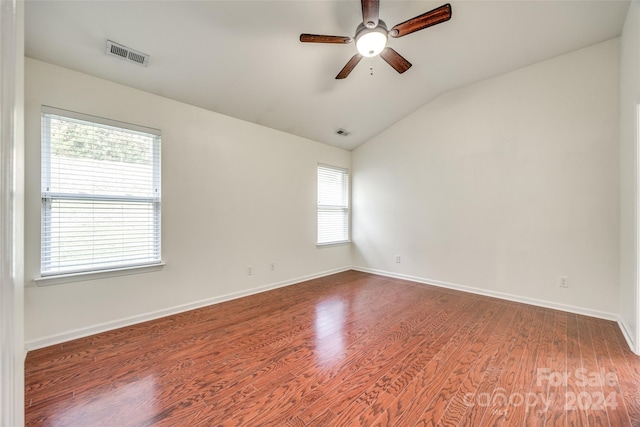 spare room featuring wood-type flooring, a healthy amount of sunlight, ceiling fan, and vaulted ceiling