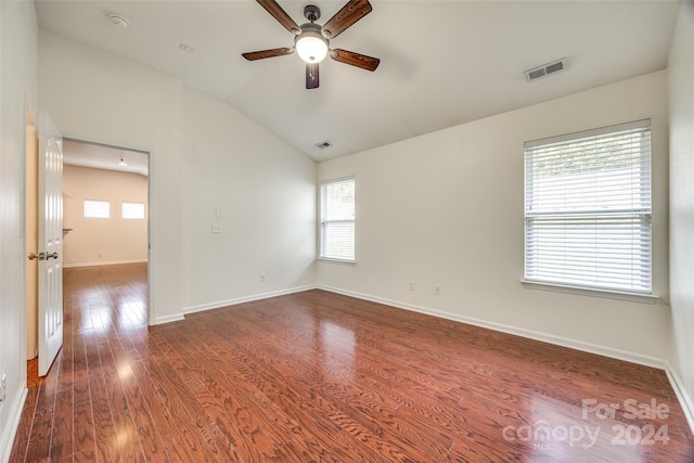 spare room with ceiling fan, a wealth of natural light, dark hardwood / wood-style floors, and vaulted ceiling