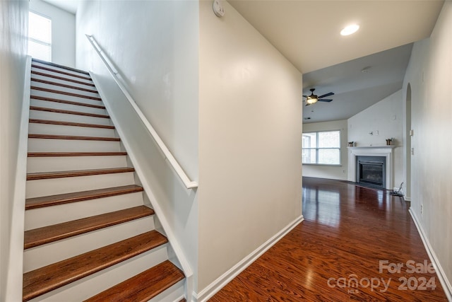 stairway with vaulted ceiling, hardwood / wood-style flooring, and ceiling fan