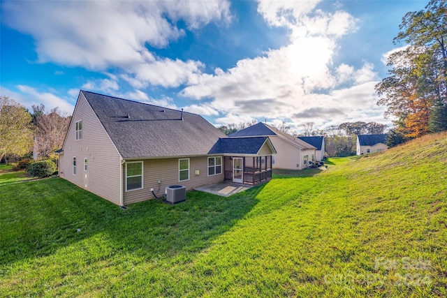 rear view of house with a patio area, cooling unit, and a lawn