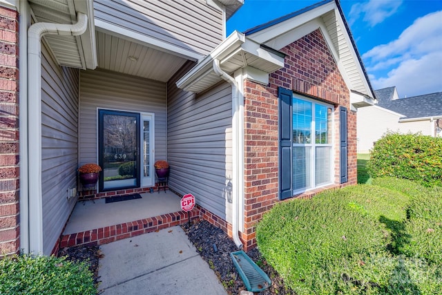 doorway to property with brick siding