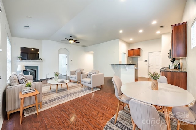 living room with dark wood-style floors, a fireplace, recessed lighting, visible vents, and a ceiling fan