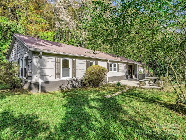 back of property with a patio area and a yard