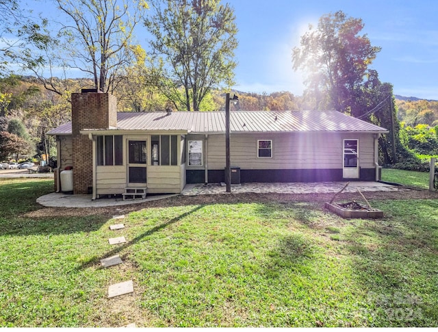 rear view of property featuring a patio and a yard