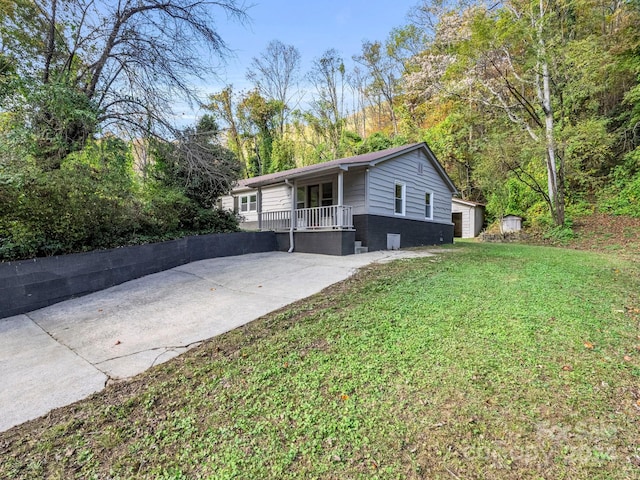 view of side of home featuring a lawn and covered porch