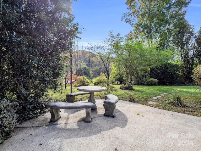 view of community with a lawn and a patio