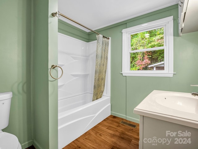 full bathroom with hardwood / wood-style flooring, vanity, shower / bath combo, and toilet