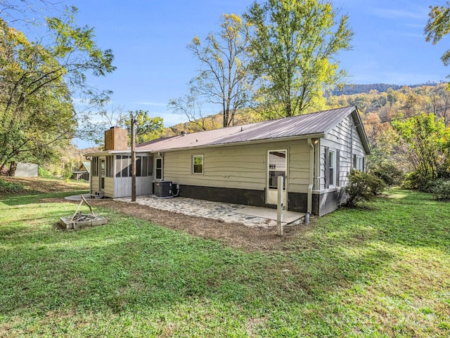 back of house featuring a patio, a sunroom, a yard, and cooling unit