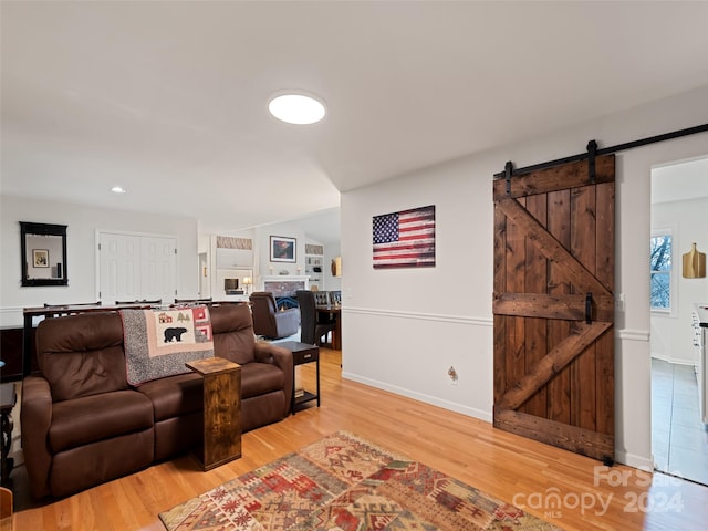 living room with a barn door and wood-type flooring