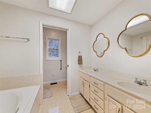 bathroom with tiled bath, vanity, and tile patterned floors