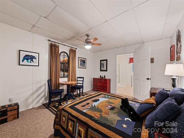 bedroom featuring ceiling fan, carpet floors, and a drop ceiling