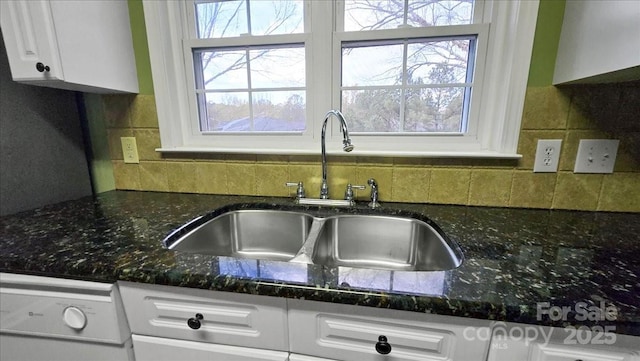 kitchen with sink, white cabinets, white dishwasher, and decorative backsplash