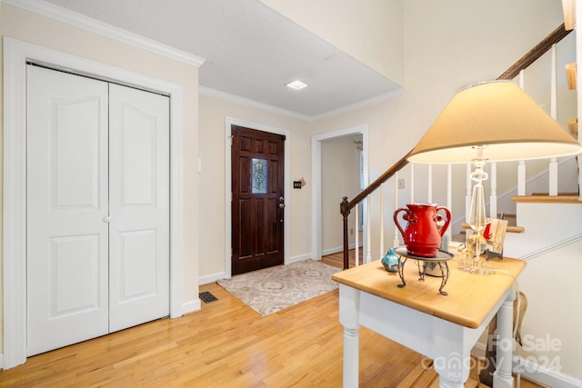 foyer entrance with hardwood / wood-style floors and ornamental molding