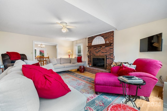 living room featuring hardwood / wood-style flooring, ceiling fan, and a brick fireplace