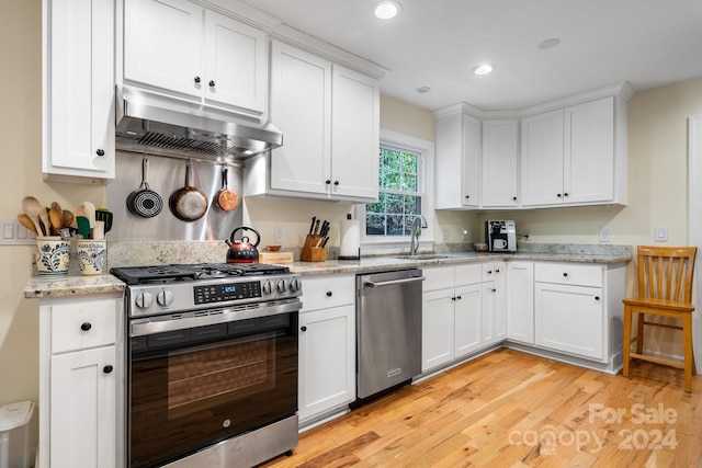 kitchen featuring light hardwood / wood-style floors, sink, appliances with stainless steel finishes, light stone countertops, and white cabinets