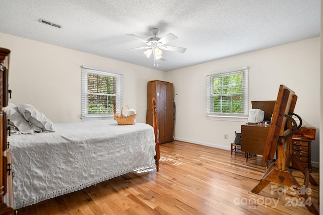 bedroom featuring a textured ceiling, hardwood / wood-style floors, and ceiling fan